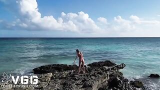 A sexy girl is completely naked on the sandy beach, showcasing her petite frame