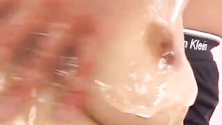 Japanese girl rubs her boobies with oil and finger, highlighting the sensual Asian handjob technique