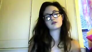 A student with glasses plays with her tits and ass in a steamy video chat