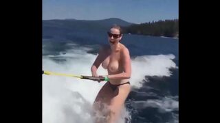 A girl is having fun on the water skiing topless