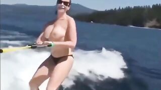 A girl is having fun on the water skiing topless