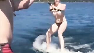 A girl is having fun on the water skiing topless