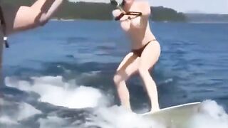 A girl is having fun on the water skiing topless