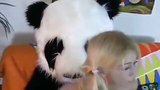 A young blonde has sex with a guy in a panda costume, using a dildo