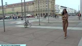 A naked girl is walking on the streets of the city and showing herself