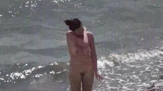 A couple of nudists enjoy each other on the beach
