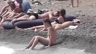 A couple of nudists enjoy each other on the beach