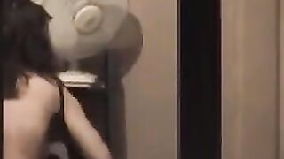 He admires himself in the mirror standing in front of him completely naked