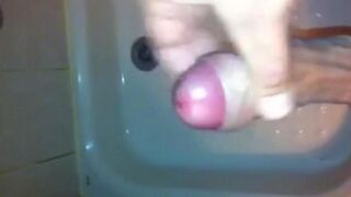 The kid masturbates his dick under the shower jet