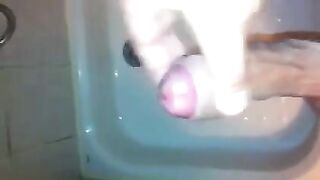 The kid masturbates his dick under the shower jet