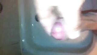 The kid masturbates his dick under the shower jet