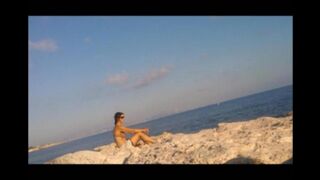 The baby basks in the sun completely naked on the beach