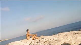 The baby basks in the sun completely naked on the beach