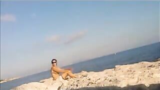 The baby basks in the sun completely naked on the beach