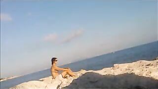 The baby basks in the sun completely naked on the beach