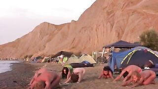 A group of girls are playing volleyball naked on the beach
