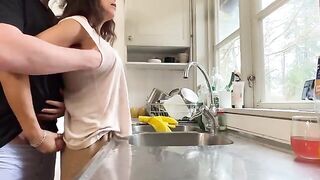 A busty woman is being fucked in the kitchen by her husband