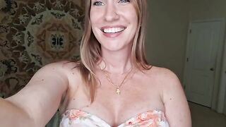 A woman massages her breasts with shimmering oil, showcasing a sensual JOI performance