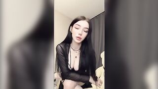 A girl in black plays with her pussy and a dildo, embodying the goth vibe